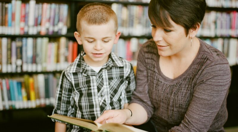 boy in gray sweater beside boy in gray and white plaid dress shirt