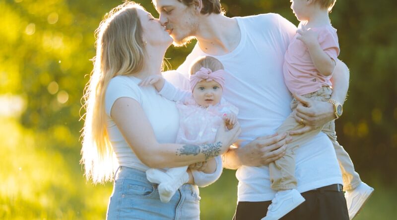 a man and woman holding a baby in a field